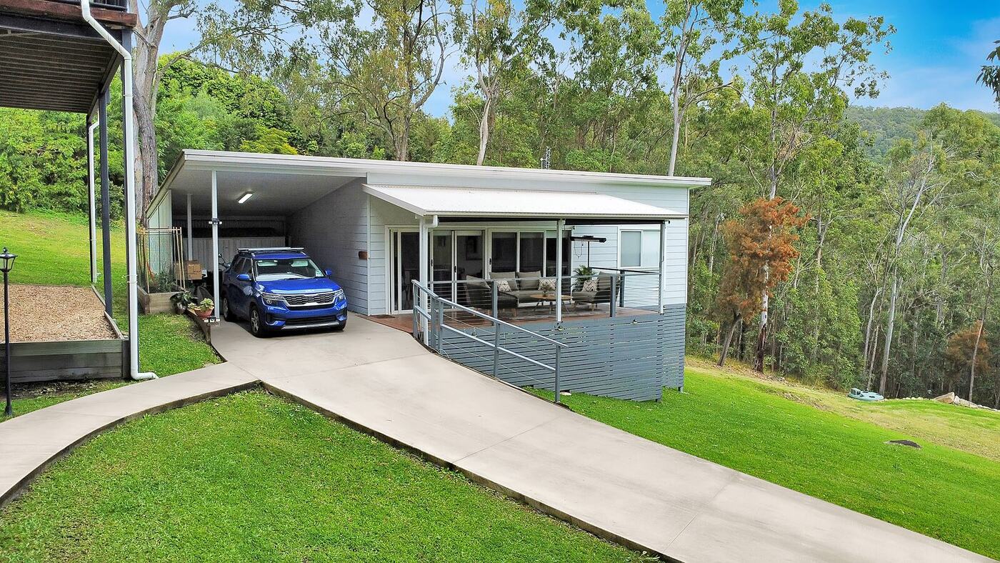 Carport and driveway beside the dwelling, with the main house above