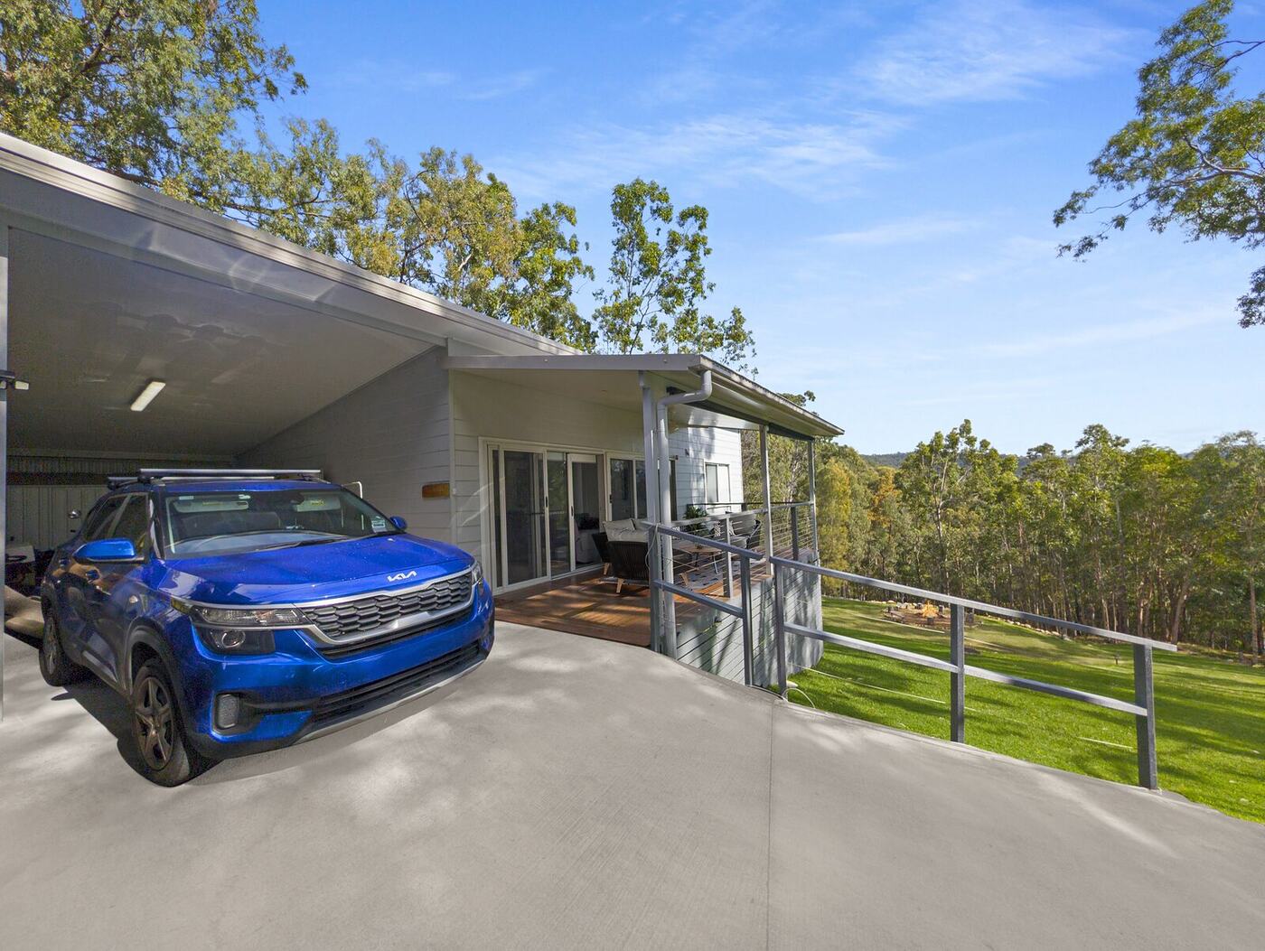 Attached carport with a handrail beside the entry path
