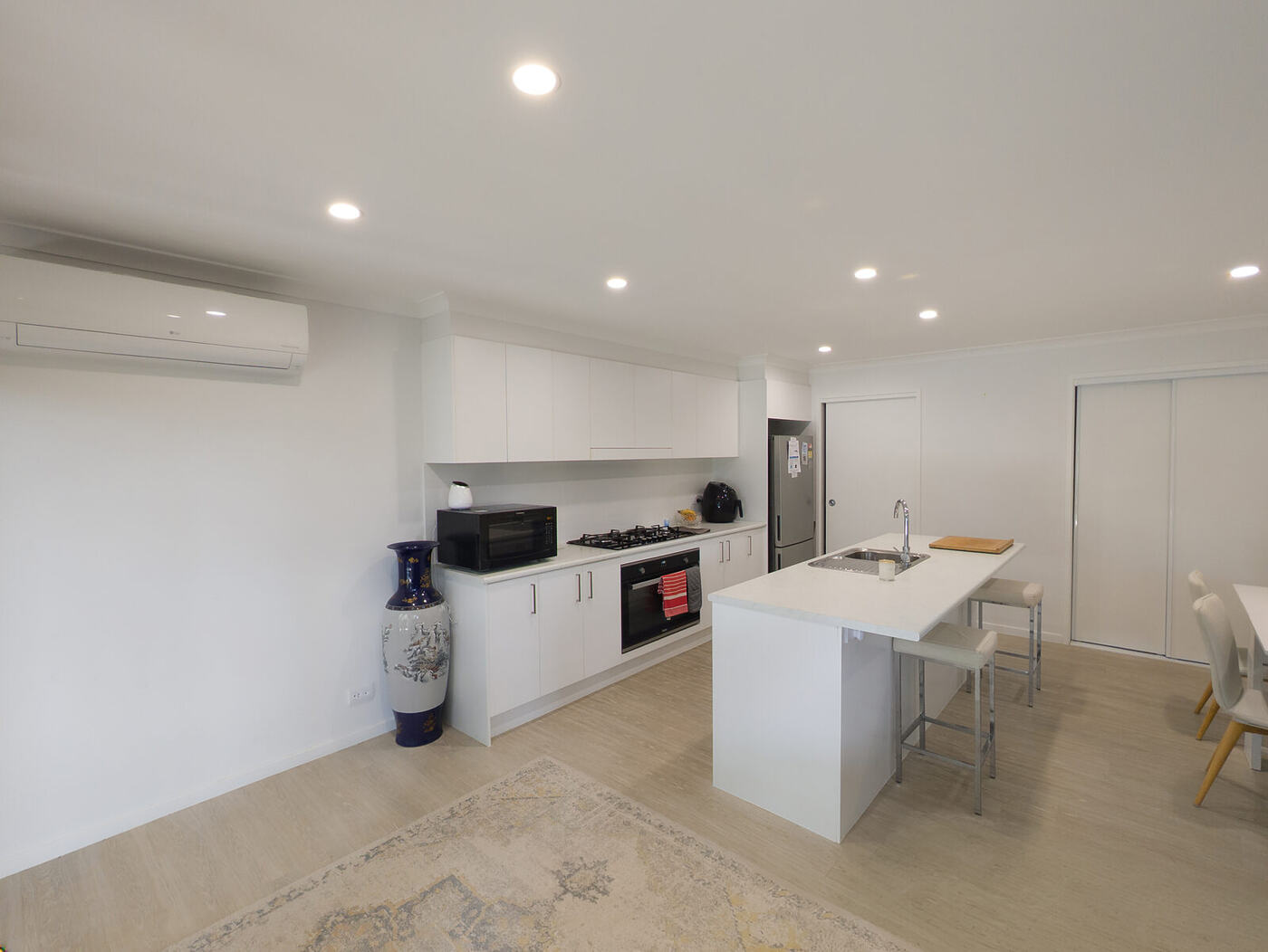 Open-plan kitchen with an island bench, wall oven and cooktop