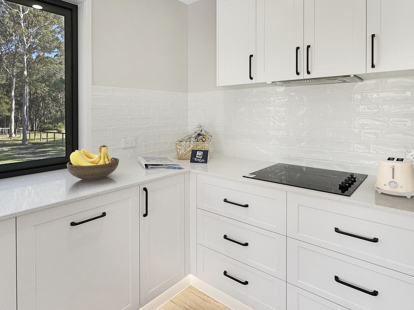 Kitchen corner with cooktop, tiled splashback and a bushland window