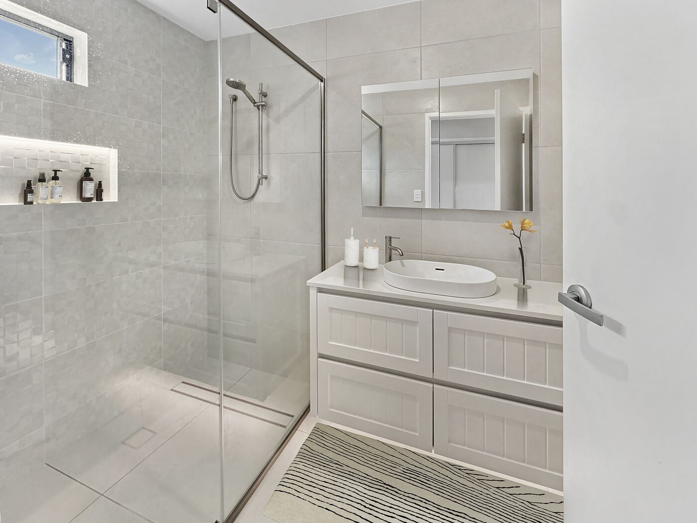 Bathroom with a level-entry shower, niche and vanity